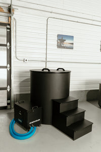 Black ice bath tub with lid on, chiller to the left and steps to the right